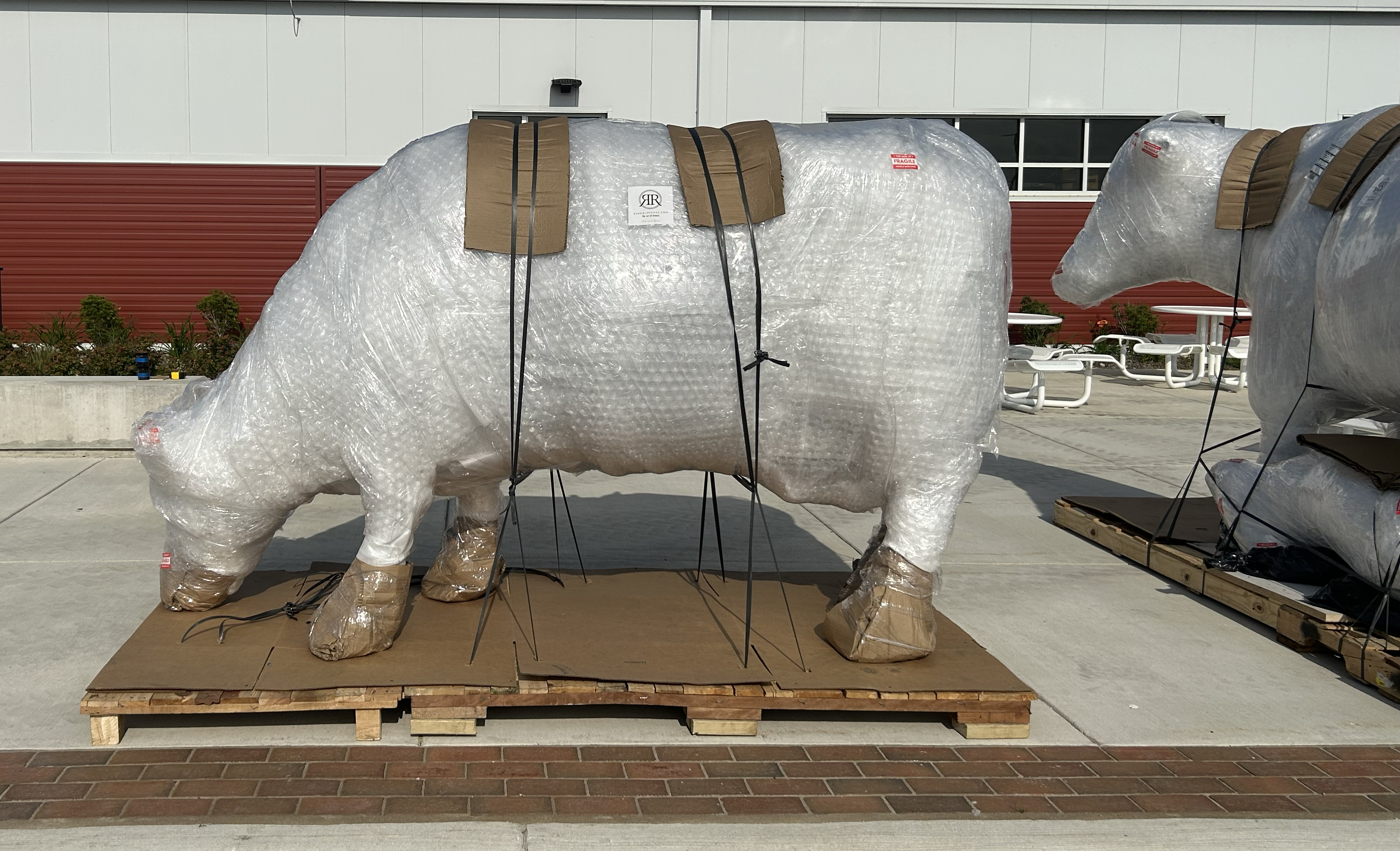 statues still in a thick white material for delivery stand on pallets waiting to be installed