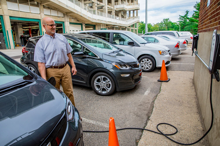 Transportation Services manager Brian Watts charges one of the Chevy Bolt electric cars