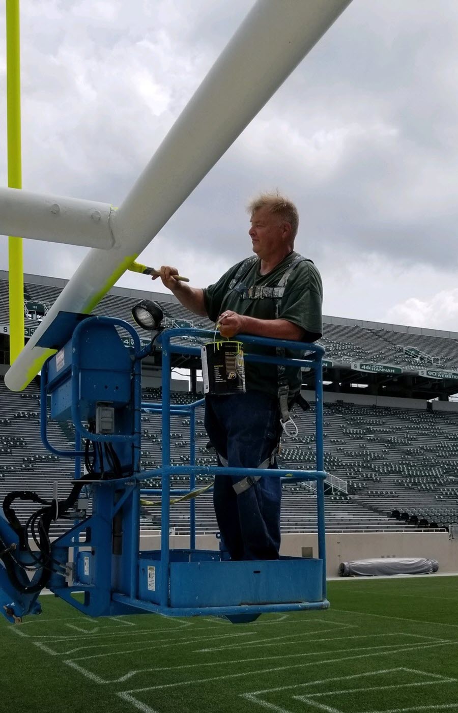 Mike McPherson in lift painting the Spartan Stadium goalpost