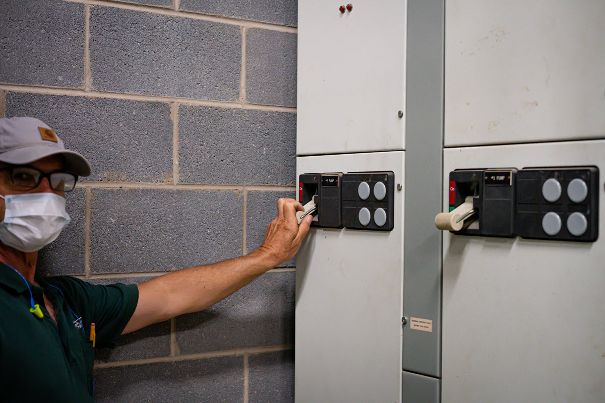 Photo of reservoir crew member switching off reservoir water pumps to switch over to the gravity-fed storage tower