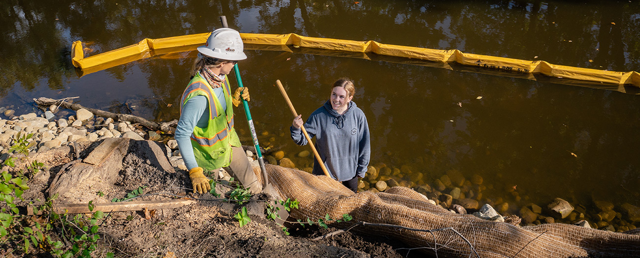 MSU student assisting with riverbank resoration