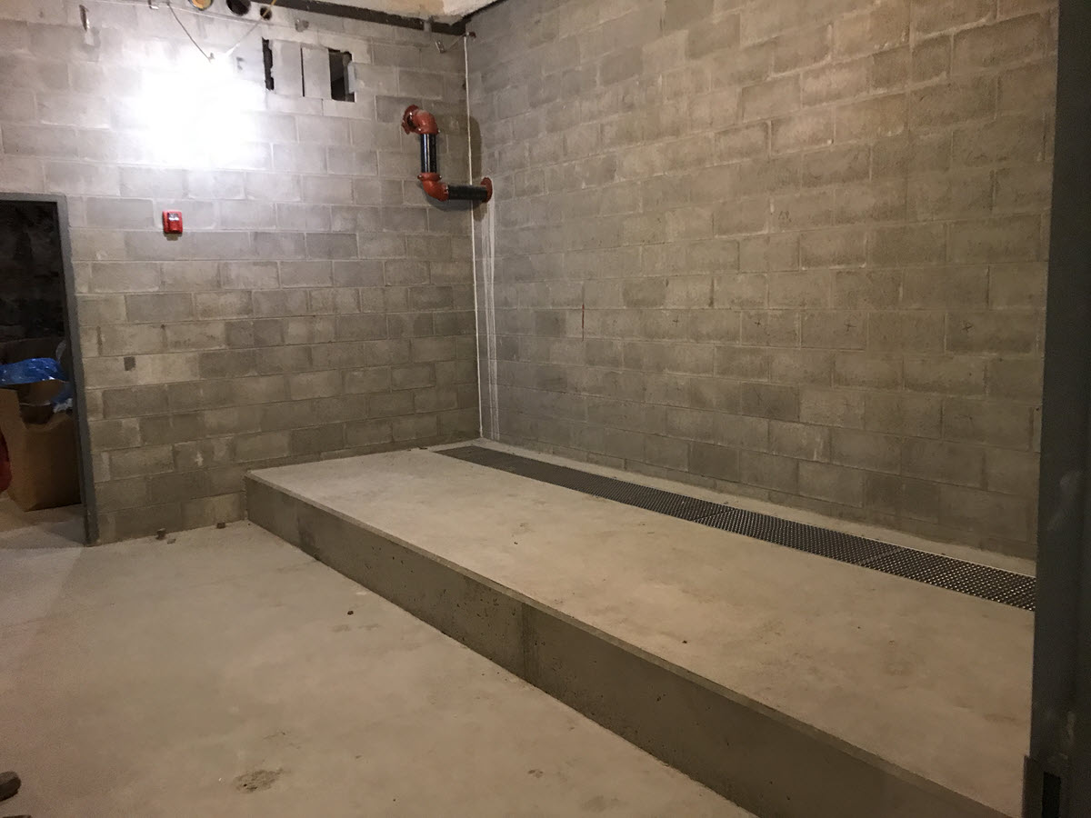 New laundry room will house equipment that can easily drain into communal trough at back of platform