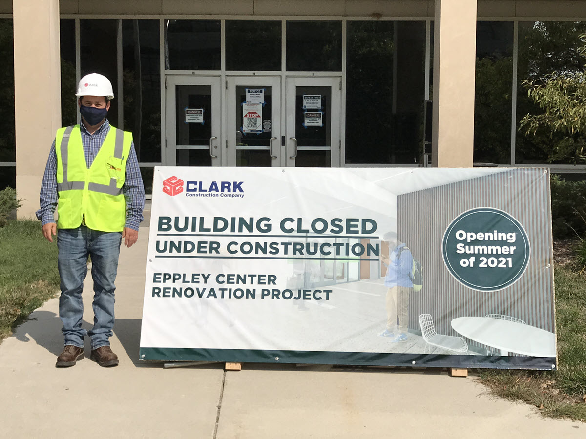 Project manager, Tony Rhodes standing in front of construction sign at entrance to Eppley. The Eppley Center contains the largest college on campus - Hospitality and Business