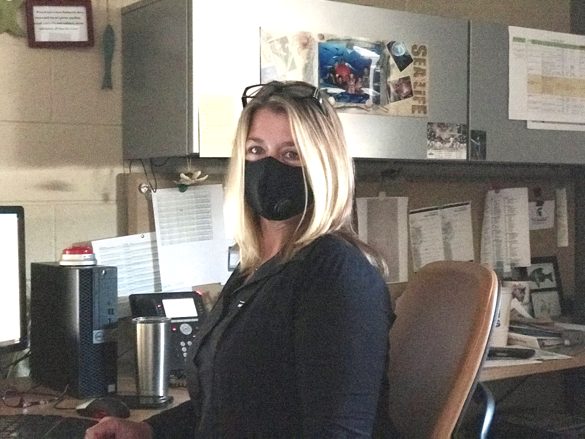 Photo of Angie Zell in her office, wearing a face mask