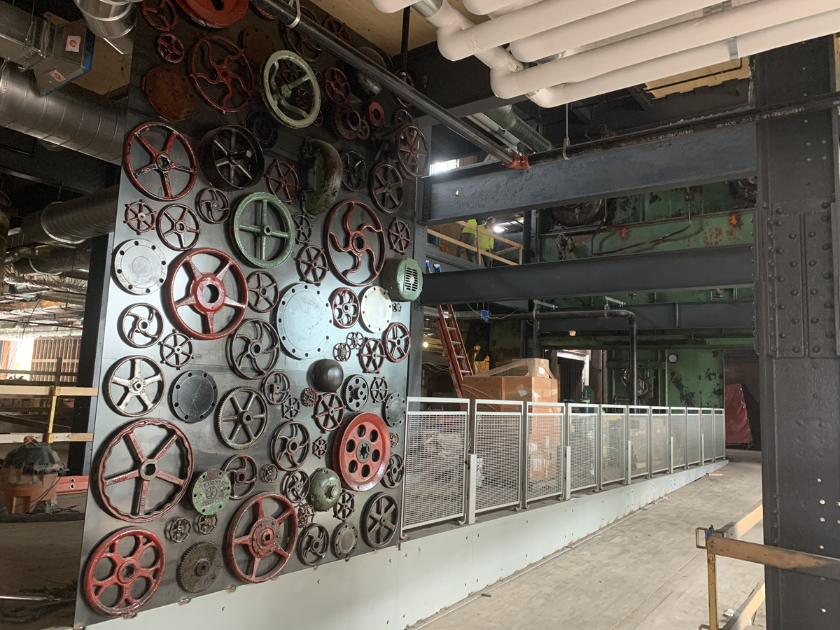 Interior photo showing art installation made from old valve handles from the Shaw Lane Power Plant