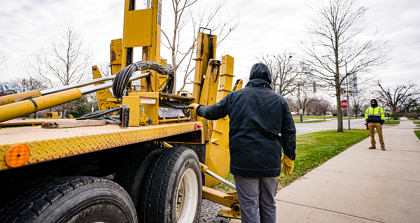 Two IPF employees communicating as they use the large, Big John tree planter truck