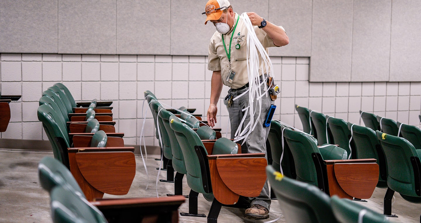 IPF employee carrying plastic straps used to band chairs in a locked position
