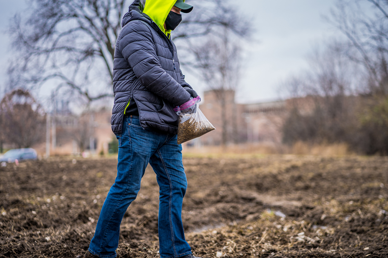 Josh Ridner of Landscape Services assists in spreading seed mixture