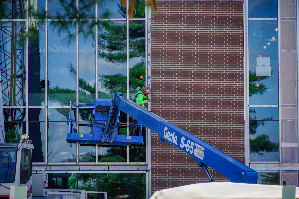 Photo of worker working on brick exterior of STEM facility