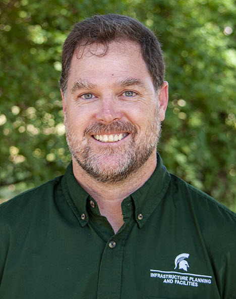 Photo of Josh Sego in front of greenery