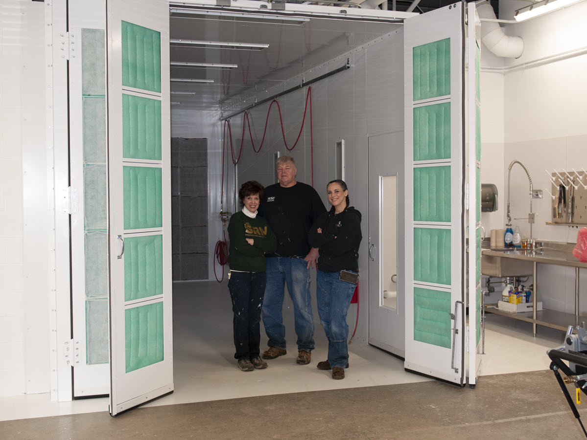 Photo of Pam Hebeler, Mike McPherson and Jessica Partain standing in the new paint booth located in the IPF Paint Shop