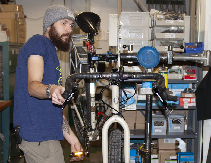 MSU Bikes student staff member Anthony Rendi working on bicycle