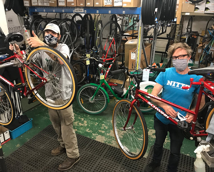 Anthony Rendi and Aubrey Hoermann wearing protective face masks while servicing bicycles in the Service Center shop.