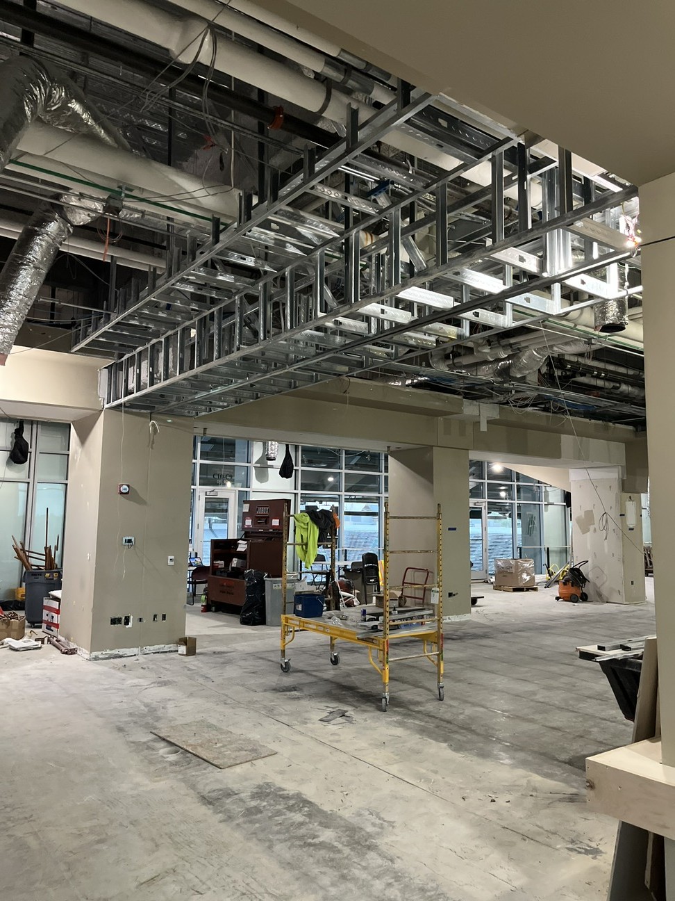 interior space under construction with completed drywall and exposed metal beams and HVAC in ceiling