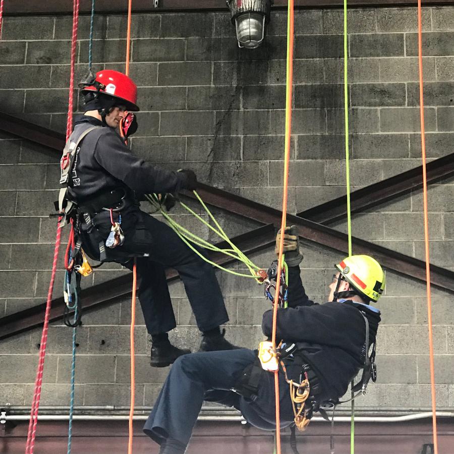 Fire department staff climbing ropes at the power plant