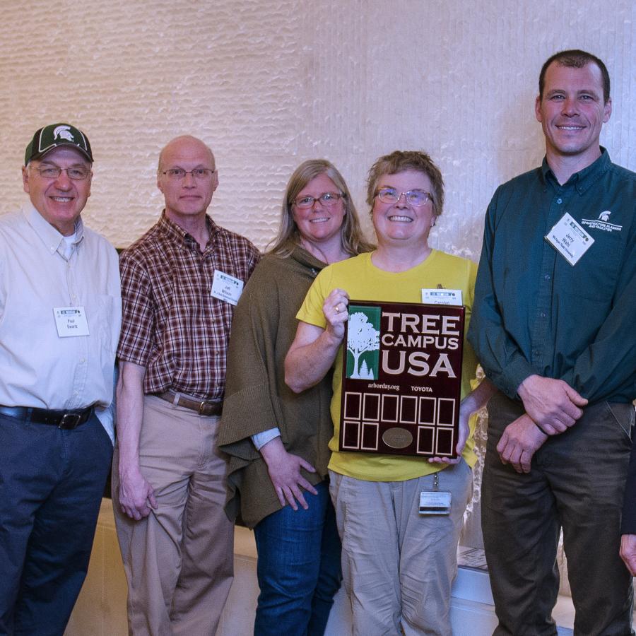 IPF staff holding Tree Campus USA award