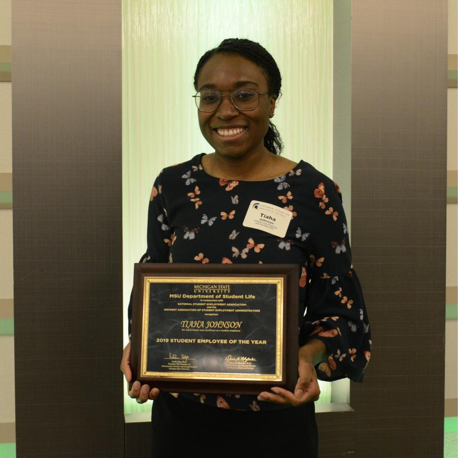 Tiaha Johnson holding her student employee of the year award