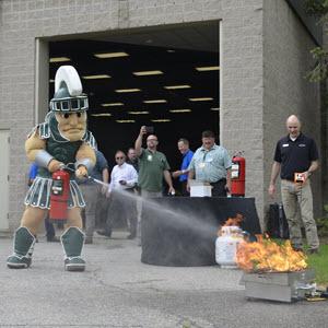 Photo of Sparty using a fire extinguisher