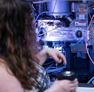 Photo of Dr. Kristin Parent in front of cryo-EM machine