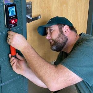 Eric Simmon installing a biometric scanner in Jenison Field House