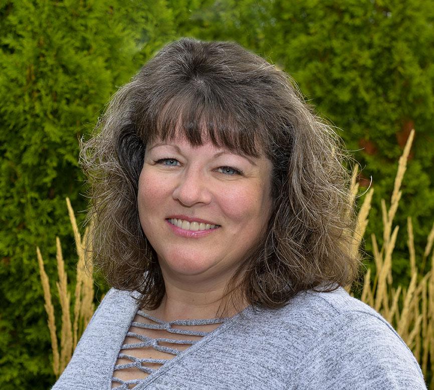 Michelle Rutkowski, a white woman with shoulder length brown hair, smiles at the camera