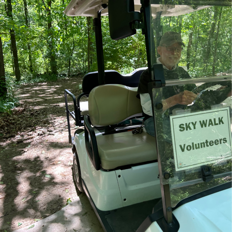 Volunteer heading out to the Sky Walk on a golf cart. 