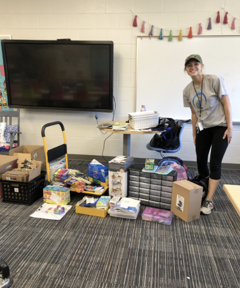 2021 winning teacher standing next to donated school supplies 