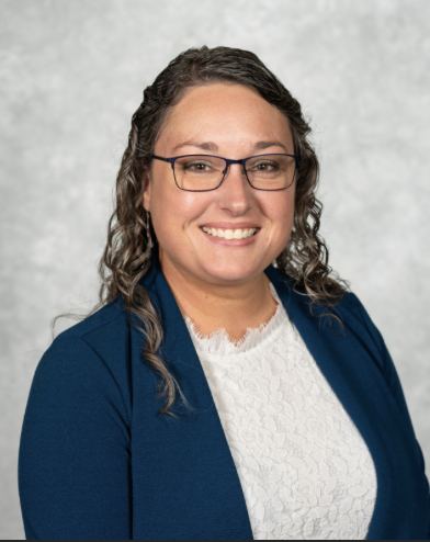 Kelly Feister pictured against a gray background in a b ue suit jacket