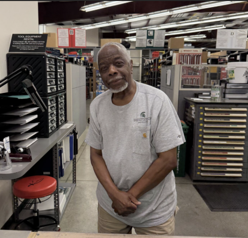 Robyn Perry in a gray shirt standing in a tool room