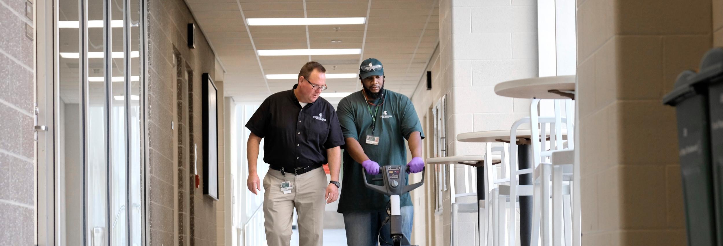 Brandon Baswell talks to a custodian.