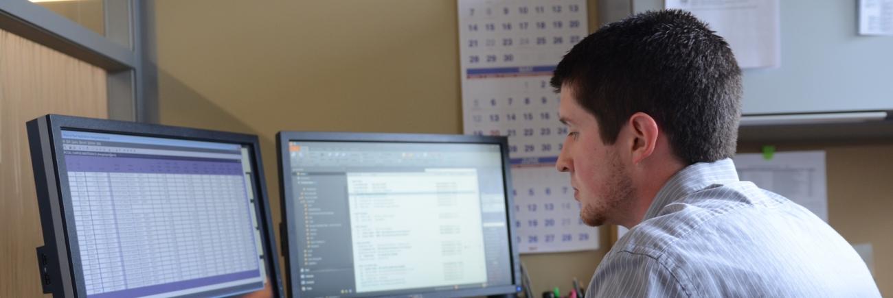 Office worker in front of computer screens