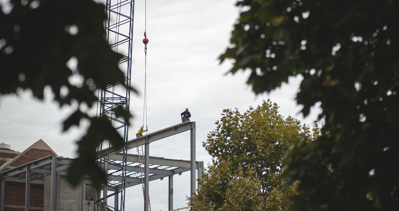 Photo of construction worker on steel beam, STEM building