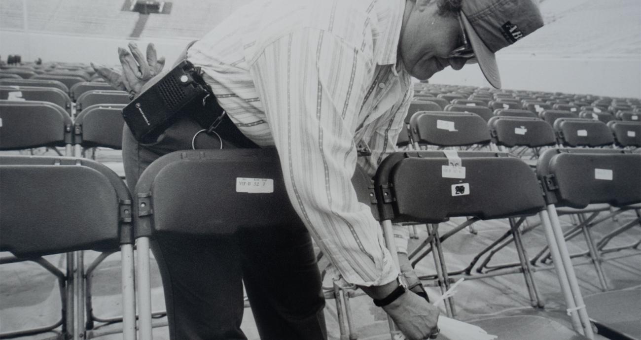 Employee tying chairs together inside Spartan Stadium