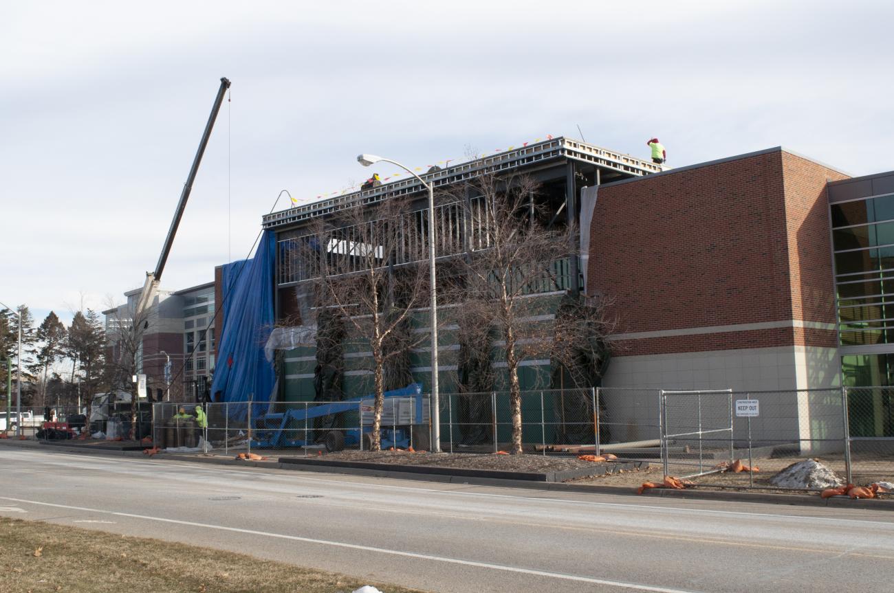 Exterior view of west side of Duffy Daugherty Football Building showing completed demolition, steel erection and roofing in progress.