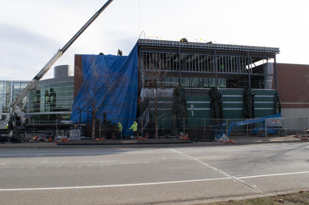 Exterior view of west side of Duffy Daugherty Football Building showing completed demolition, steel erection and roofing in progress.