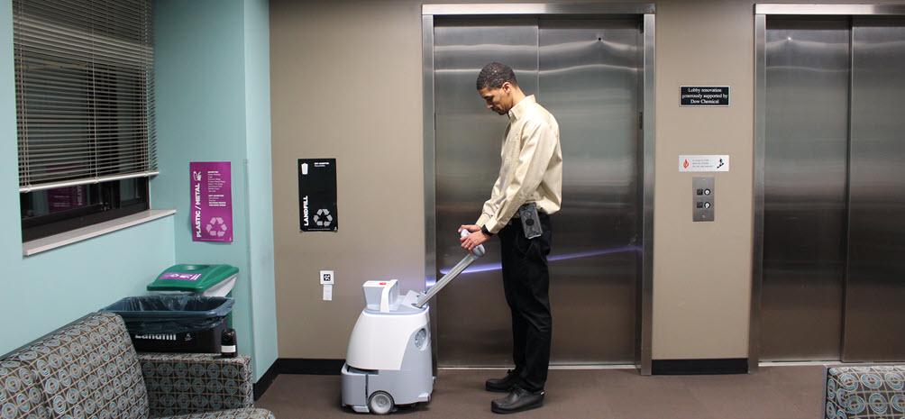 Trhile Brown moving WHIZ vacuum to the wall mounted QR code that marks its starting position
