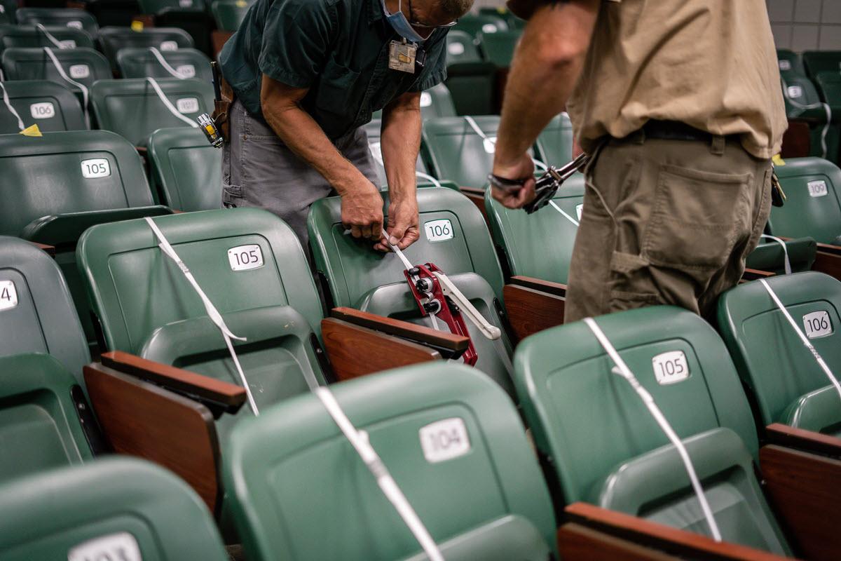 Photo of IPF crew banding auditorium classroom seats for physical distancing