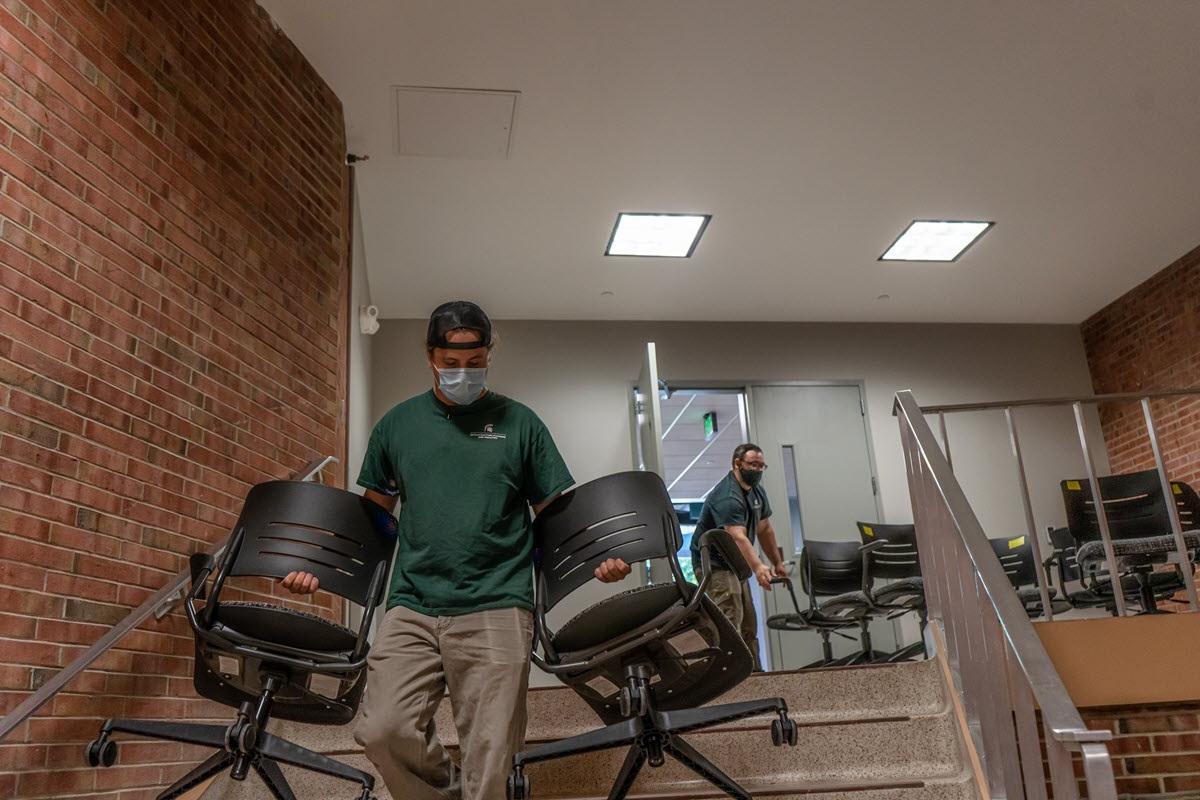 IPF Set up crew members moving chairs down stairwell