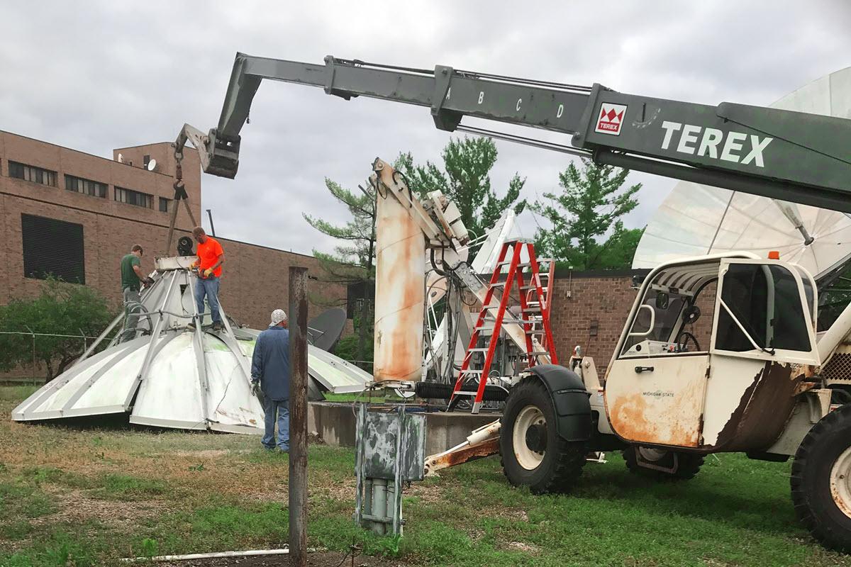 IPF crew members dismantling satellite dish at Comm Arts