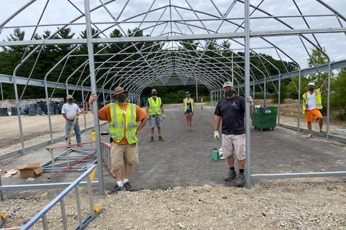Photo of Dr. John Biernbaum and Recycling Center staff in process of constructing vermicomposting hoop house.