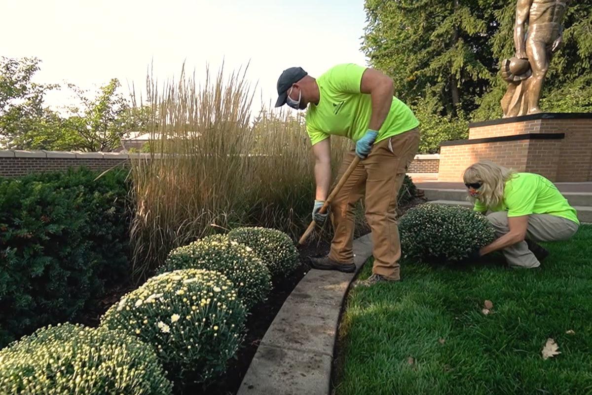 IPF Landscape Services crew members Jacob Paivarinta and Jill Arthur update Sparty's flower beds with beautiful mums to celebrate the autumn season