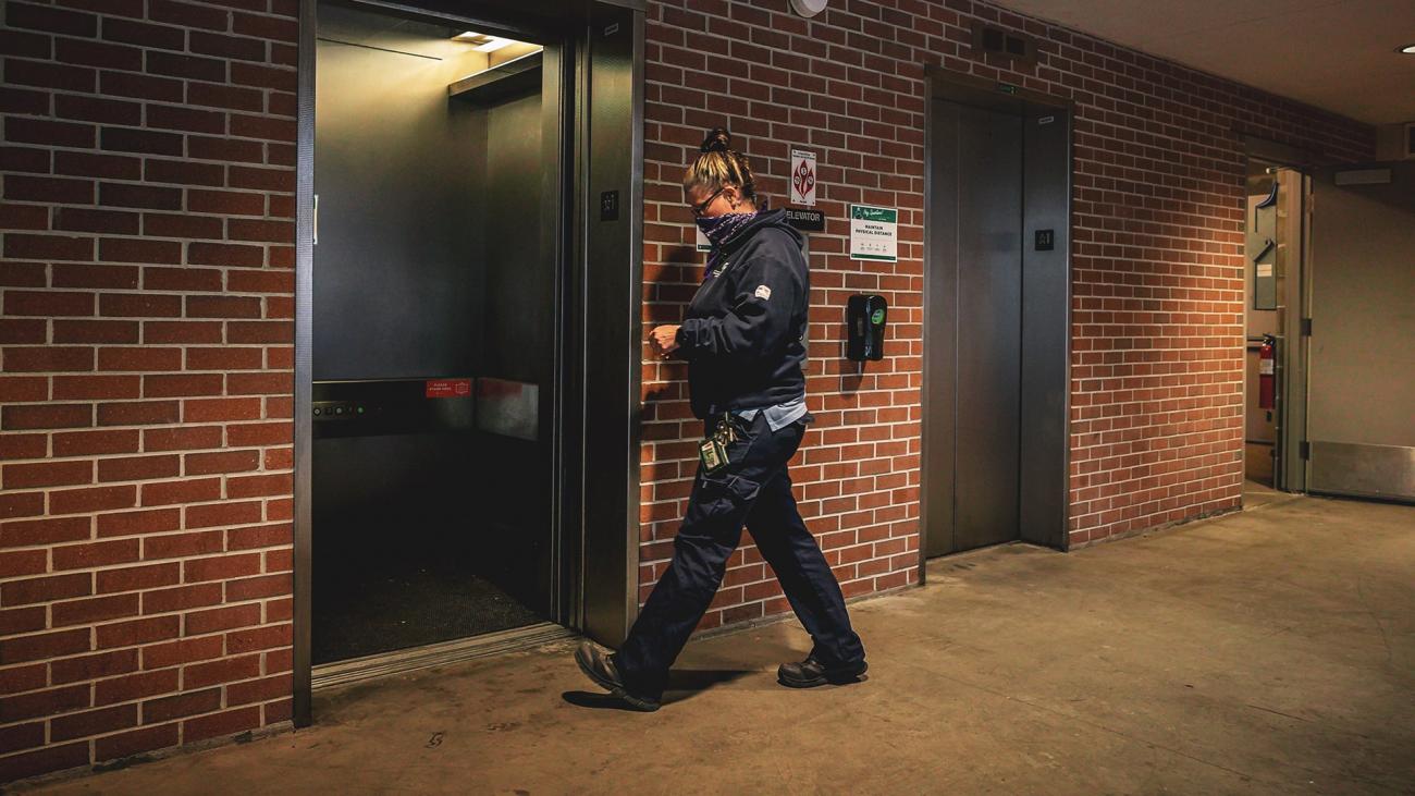 Melissa Peek, elevator mechanic, walks up to a bank of elevators at the Comm Arts ramp