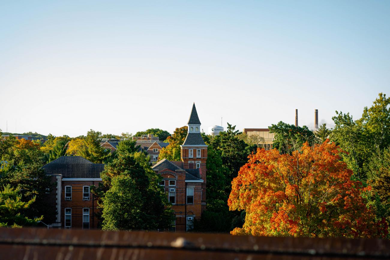 Arial view of campus with the tops of trees turning red and orange at the beginning of autumn