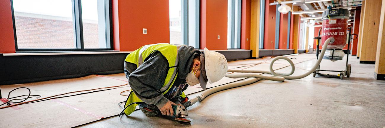 An IPF employee works on a floor in the STEM building