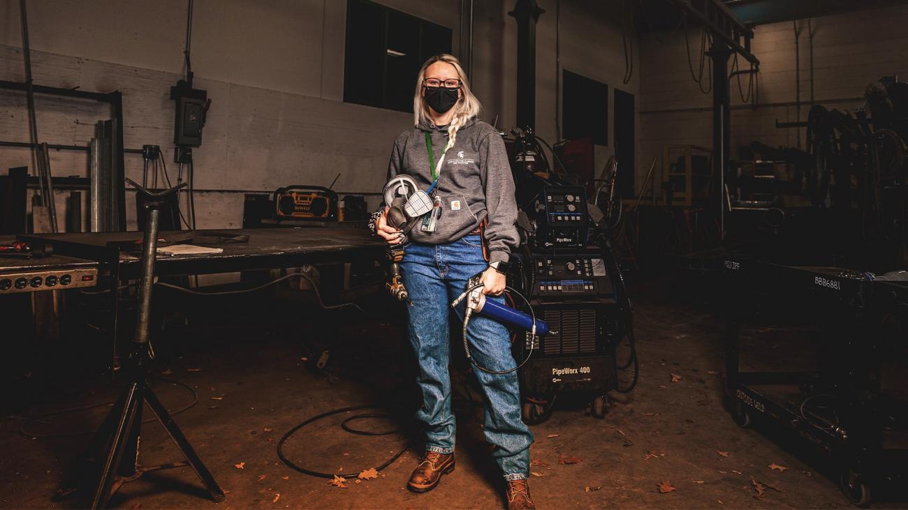 Courtney Hasse, plumber, poses with her work tools