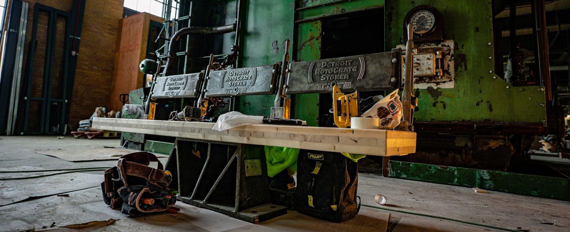 A bench in a construction area with a worker's belt and helmet