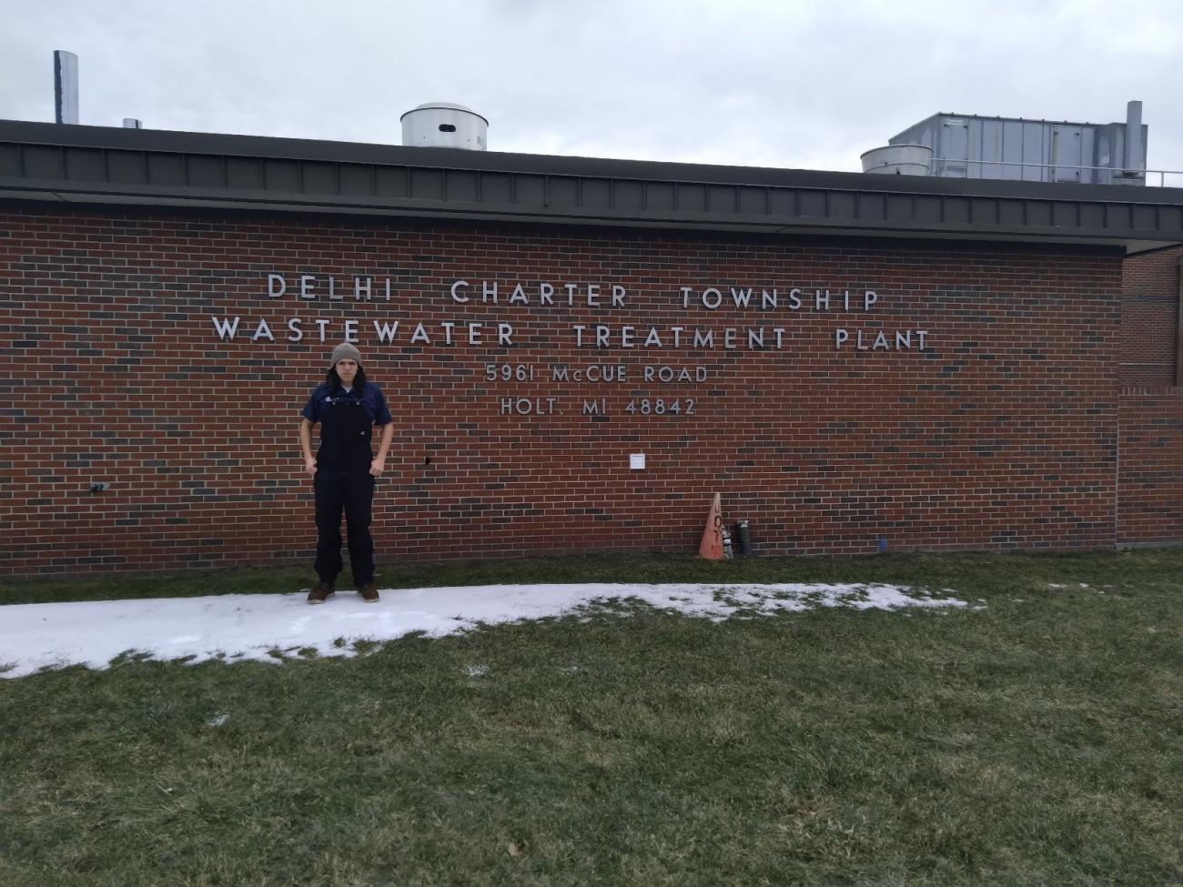 Cervantes Lalone stands outside the brick exterior of the Delhi Wastewater treatment plant