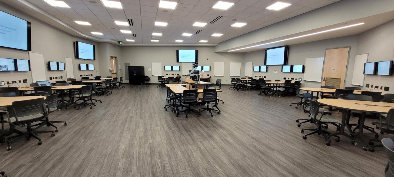 Large classroom with multiple flat screen TVs on the walls