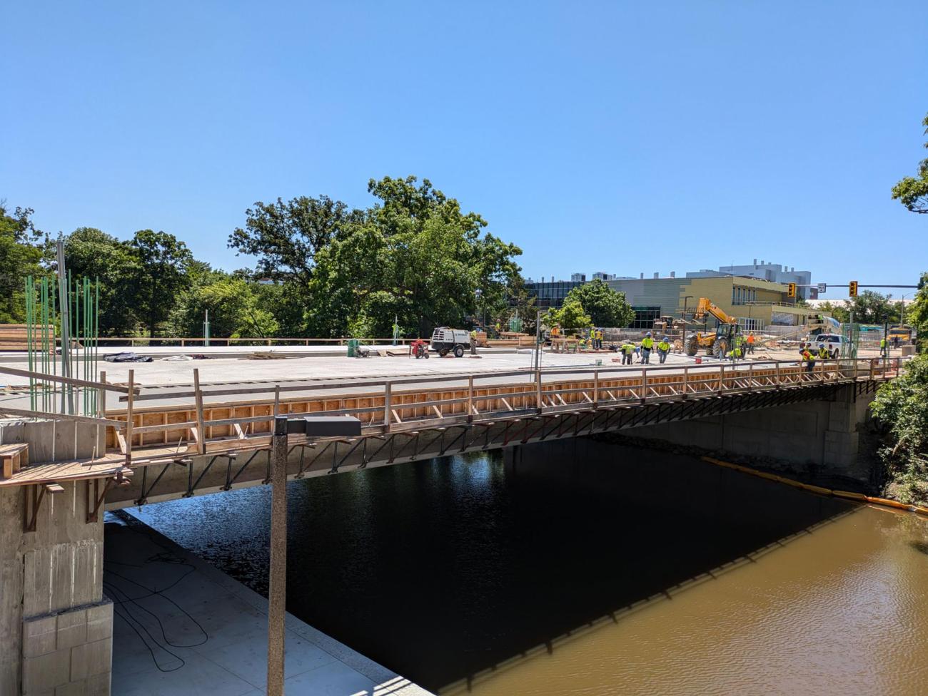 Farm Lane Bridge from pedestrian walkway, workers with floats smooth wet concrete