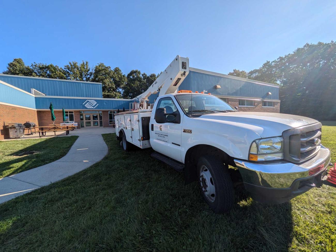 An IPF truck parked on the grass in front of the Lansing Boys and Girls Club.